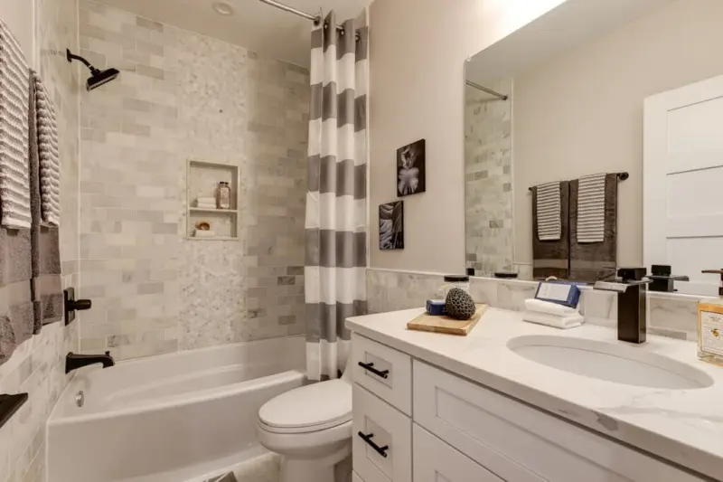 Bathroom with marble tile tub surround and white vanity