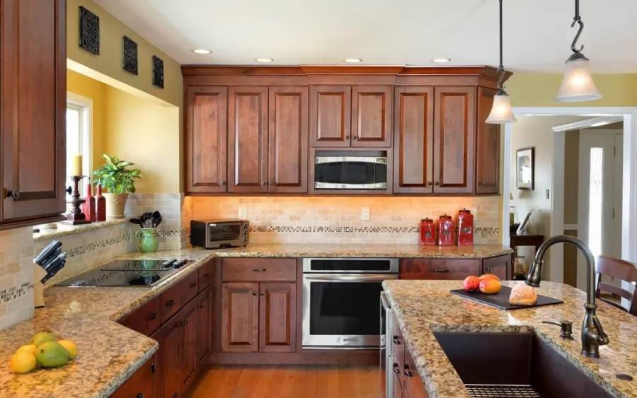 Remodeled kitchen with warm wood cabinets and granite counters